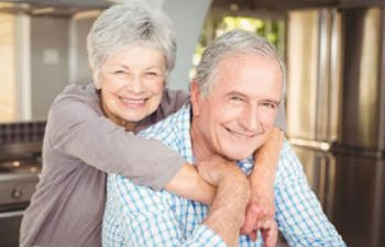 Happy cuddling senior couple at comfort of their home.