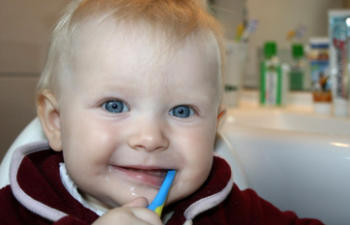 a baby with a toothbrush in its mouth