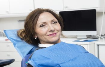 Woman in a dental chair waiting for a consultaion.