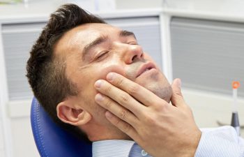 young man happy in the dentist chair