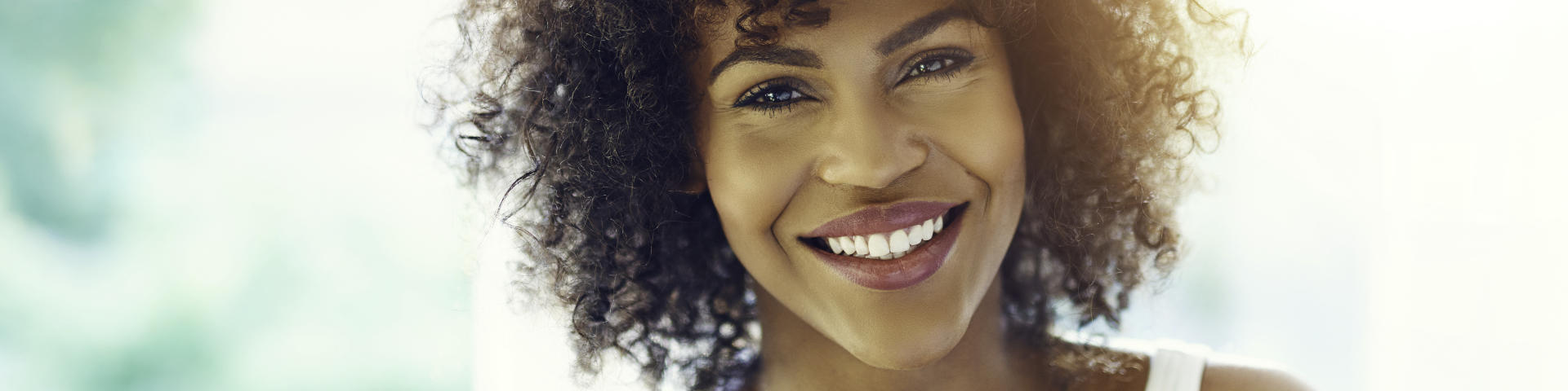 Happy Afro-American woman showing her perfect teeth in a smile.