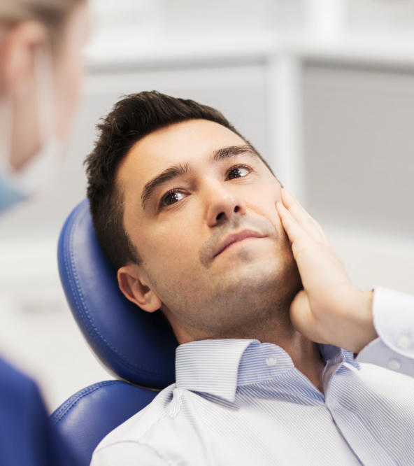 Man with severe dental pain in a dental talking to a dentist.