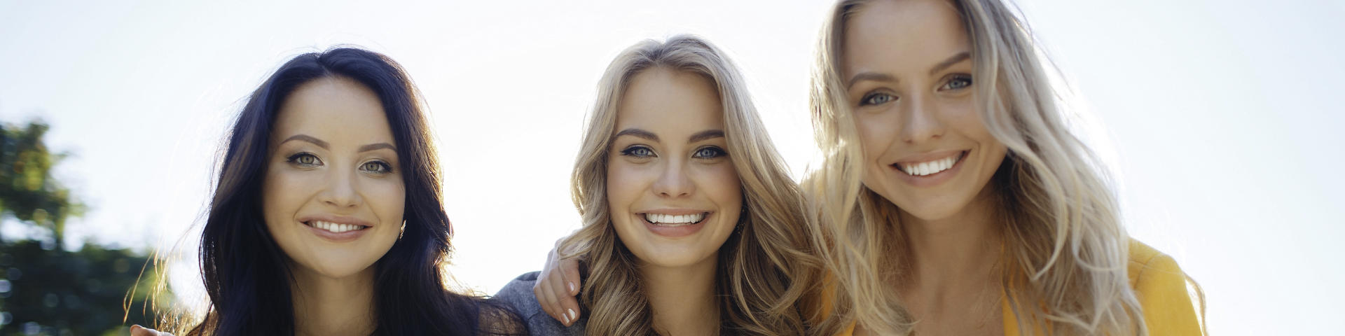 Three young woman with perfect smiles.