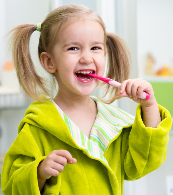 Little happy girl brushing her teeth.