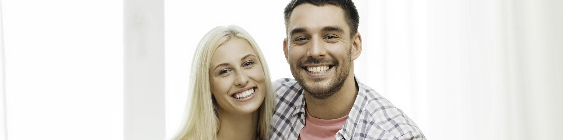 Young couple showing healthy nice teeth in their smiles.