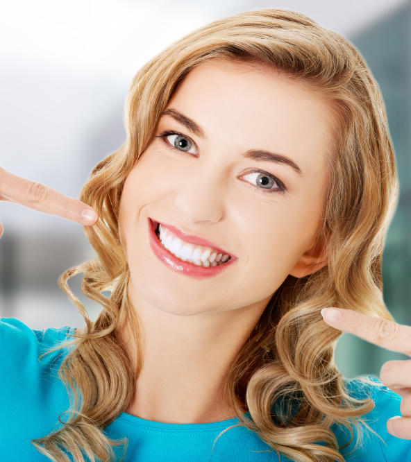 Happy woman pointing at her beautiful teeth.