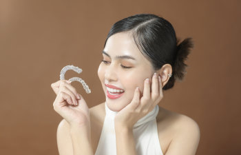 satisfied woman points at her perfect smile