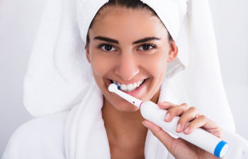 satisfied woman points at her perfect smile