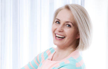 girl with black hair and a beautiful smile holds in hand invisalign